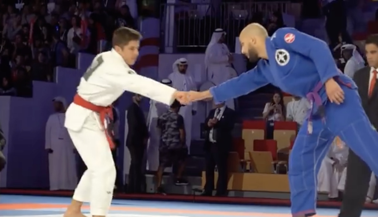Reda, en kimono bleu, salue son adversaire avant le combat, devant le public d'Abu Dhabi